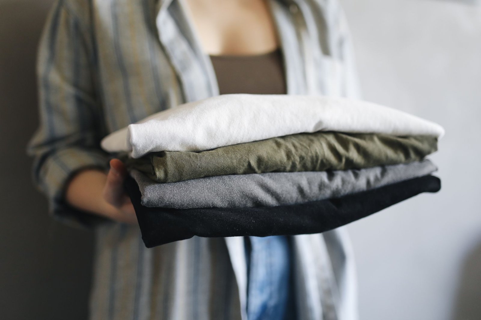 Freshly laundered clothes, neatly folded and held in a stack
